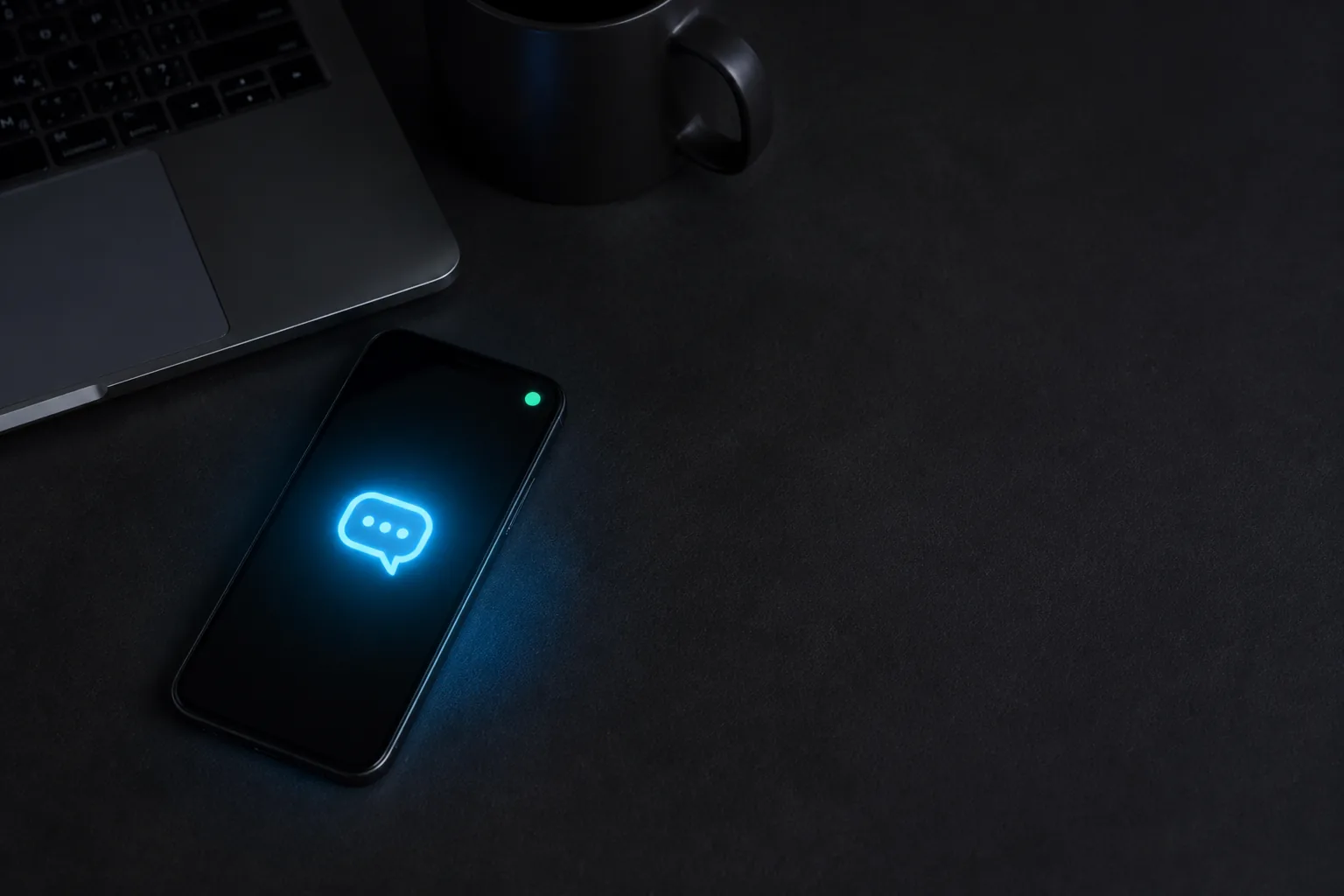 Escritorio oscuro con un teléfono que brilla en azul recibiendo un mensaje / Dark desk with a phone glowing blue receiving a message